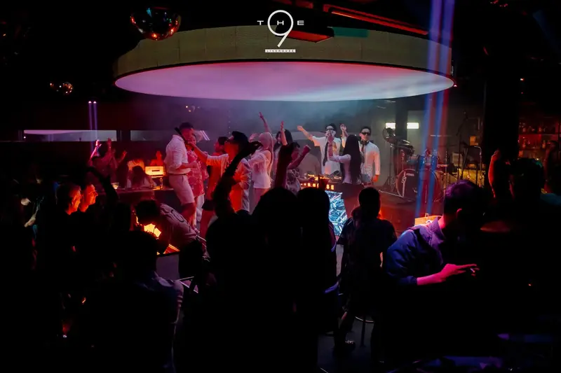 Dàn nghệ sĩ áo trắng trên sân khấu tròn The 9 Live House, khán giả vây quanh